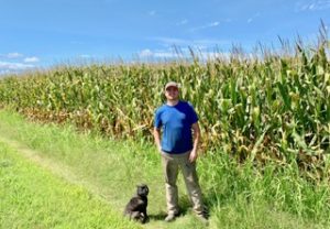 Jesse Todd on a corn field in Chesapeake with his dog, Sneaky Pete.